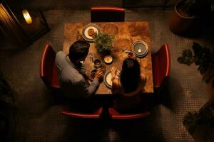 ai generado Pareja sentado a un mesa en un restaurante. ver desde arriba, un Pareja teniendo un cena fecha a un restaurante, parte superior vista, ai generado foto