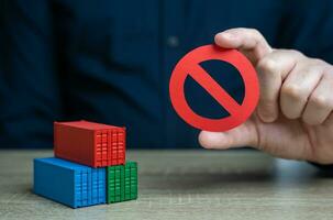 Shipping containers and prohibition symbol NO. Ban on import of goods. Sanctions and embargoes. Trade wars. Container shortage crisis. Blocking of cargo and blockade of trade routes. photo