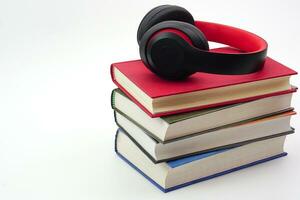 el auriculares son en apilar de libros. moderno educación y relajación concepto. foto