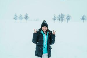 mujer turista visitando en Bien, viajero en suéter Turismo templado Siete colinas con nieve en invierno estación. punto de referencia y popular para atracciones en Hokkaidō, Japón. viaje y vacaciones concepto foto