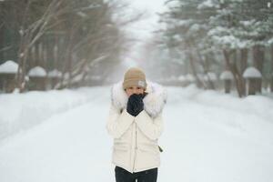 happy Traveler with Sweater and backpack walking on snow covered forest in frosty weather. Winter Travel, Adventure, Exploring and Vacation concept photo