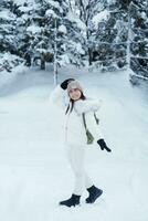 happy Traveler with Sweater and backpack walking on snow covered forest in frosty weather. Winter Travel, Adventure, Exploring and Vacation concept photo