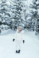 happy Traveler with Sweater and backpack walking on snow covered forest in frosty weather. Winter Travel, Adventure, Exploring and Vacation concept photo