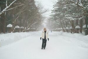 happy Traveler with Sweater and backpack walking on snow covered forest in frosty weather. Winter Travel, Adventure, Exploring and Vacation concept photo