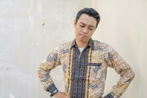 Young Indonesian wear batik traditional culture of Indonesia with sigh gesture. photo