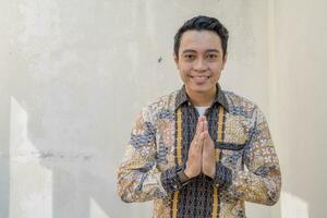 Young Indonesian wear batik traditional culture Indonesia with sweat gesture photo