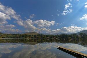 Reflection of autumn colors and clouds on the lake photo