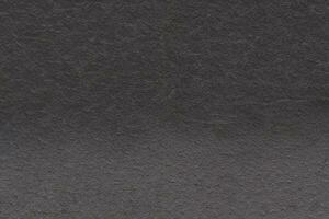 Dark gray background from natural slate. Texture of stone closeup. Graphite background macro photo