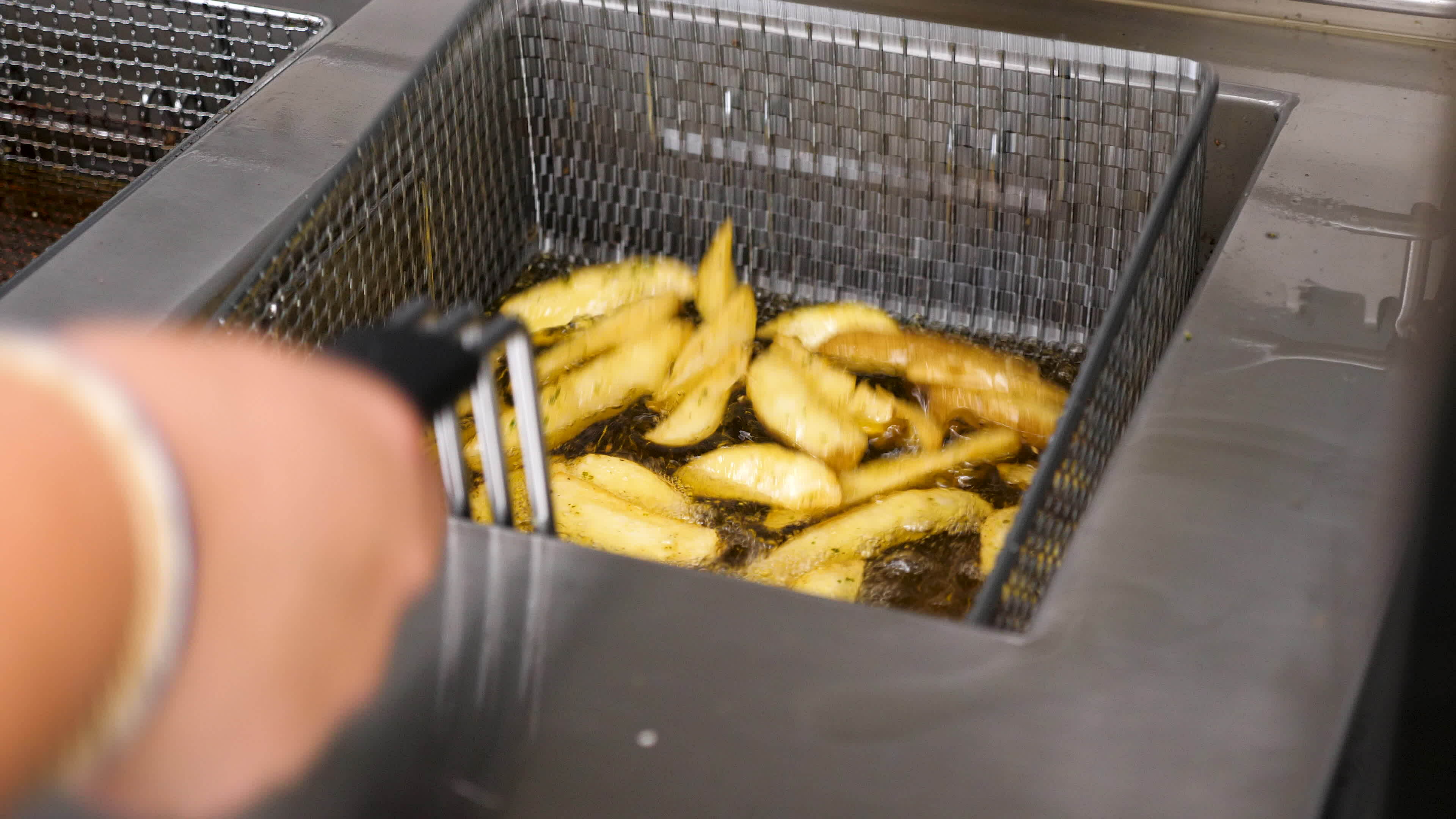 French fries boiling in oil cooking at the restaurant kitchen 35017601 Stock Video at Vecteezy