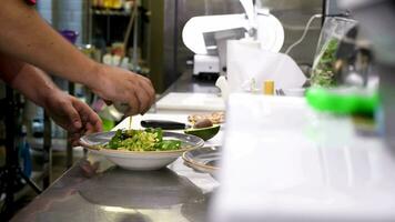 Cook pouring souce on avocado salad in restaurant kitchen video