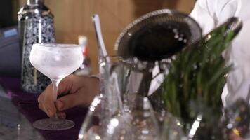 Barman putting a frozen glass in front on the bar desk getting readdy to make a cocktail video