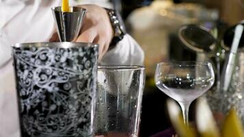 barman torrencial alcohol en un vaso. haciendo un cóctel. cerca arriba imágenes video