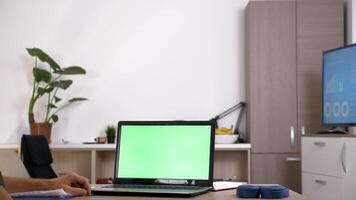 man på hans skrivbord i främre av dator med grön skärm. falsk upp video för din data. dolly reglaget 4k antal fot