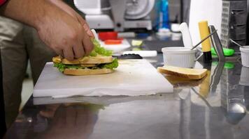 Cook making a sandwich in restaurant kitchen. Close up 4K footage video