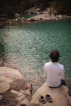 Man on the background of a mountain lake, tranquility and unity with nature in Turkey. authentic photo