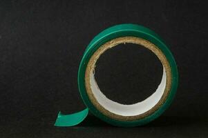 a roll of green tape on a black surface photo