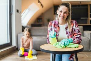 Happy mother and daughter cleaning house together photo