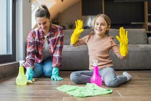 Happy daughter and mother cleaning house together photo