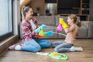 contento madre y hija teniendo divertido mientras limpieza casa juntos foto