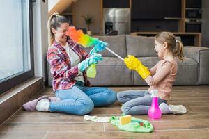 contento madre y hija teniendo divertido mientras limpieza casa juntos foto