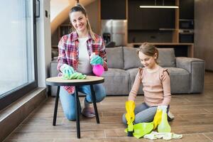 Happy mother and daughter cleaning house together photo