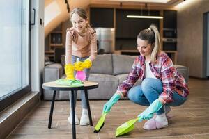 Happy mother and daughter cleaning house together photo