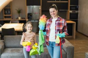 Happy mother and daughter cleaning house together. photo