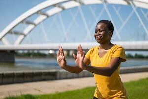 joven mujer disfruta hacer ejercicio Tai chi al aire libre foto