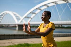 Young woman enjoys exercising Tai Chi outdoor photo