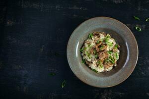 Italian cuisine - risotto with mushrooms. Cooked arborio rice with parmesan cheese and mushrooms photo