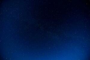 el noche cielo es lleno con estrellas y el Luna foto