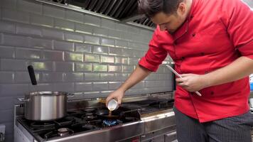 Cook in restaurant kitchen preparing a souce for clients video