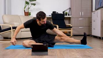 Man repeating exercises after what he sees on a digital tablet PC in front of him video