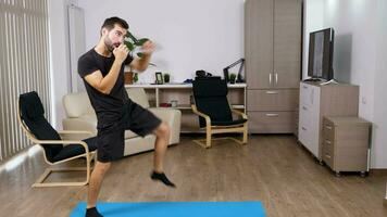 athlétique homme coups de pied et perforation dans le vivant chambre. il est pratiquant sport à Accueil video