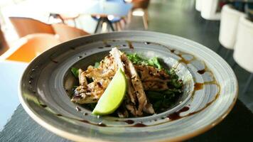 pOV antal fot av tallrik med avokado sallad och grillad kyckling kött på en tallrik i restaurang gående till de kunder. servitör punkt av se video