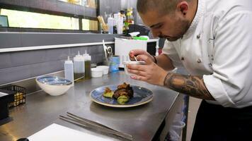 Cook pouring honey over a grilled beef steak in restaurant kitchen video