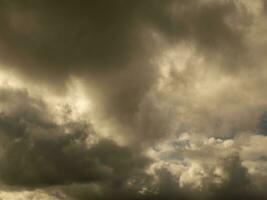 Fluffy clouds over sunset sky. Fluffy cumulus cloud shape photo, gloomy cloudscape background, smoke in the sky photo