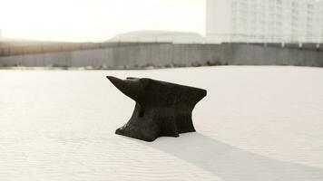 Old anvil on a sandy beach photo