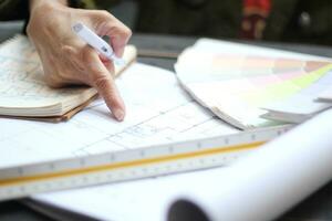 Hands of Asian female engineers are working on construction drawings on site. photo