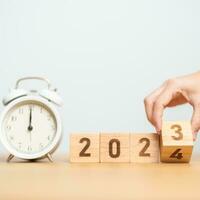 Happy New Year with vintage alarm clock and flipping 2023 change to 2024 block. Christmas, New Start, Resolution, countdown, Goals, Plan, Action and Motivation Concept photo