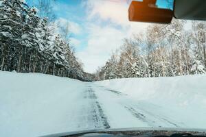 Beautiful snow road forest view during car driving in winter season. Winter travel, Road trip, Adventure, Exploring and Vacation concepts photo