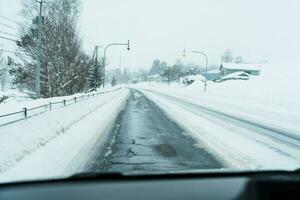 Beautiful snow road forest view during car driving in winter season. Winter travel, Road trip, Adventure, Exploring and Vacation concepts photo