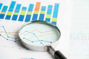 Magnifying glass on graph paper. Financial development, Banking Account, Statistics, Investment Analytic research data economy, Business concept. photo