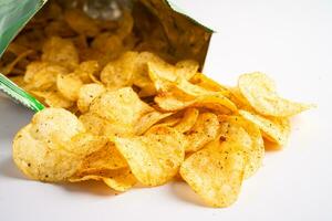 Potato chips, delicious spicy for crips, thin slice deep fried snack fast food in open bag. photo