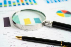 Magnifying glass on graph paper. Financial development, Banking Account, Statistics, Investment Analytic research data economy, Business concept. photo