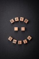 A concept consisting of the inscription of the word smile, with round emoticons on a dark concrete background photo