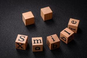 A concept consisting of the inscription of the word smile, with round emoticons on a dark concrete background photo