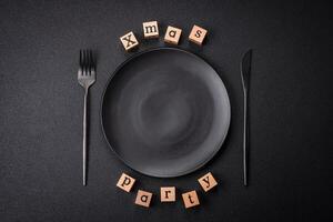 Christmas party inscription with wooden cubes on a dark concrete background photo