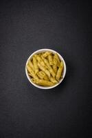 Delicious fresh pasta penne with green pesto sauce with basil, salt and spices photo