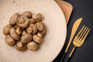 Delicious juicy whole champignons baked on the grill with salt and spices photo